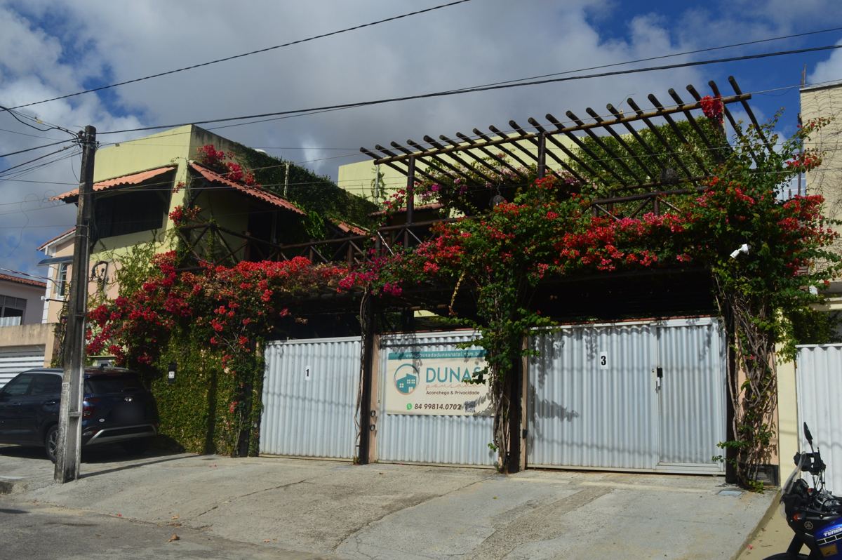 Fachada da Pousada Dunas, com portão, buganvília e pergolado